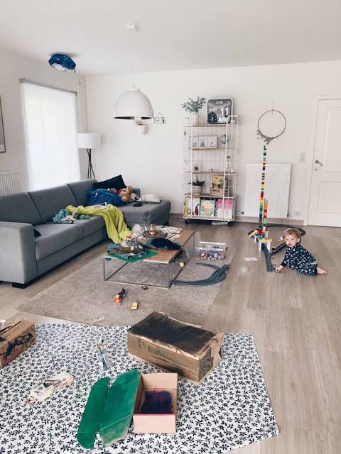 SPeelgoed Stel ruimt samen speelgoed op in de woonkamer als voorbeeld van samenwerken in een relatie